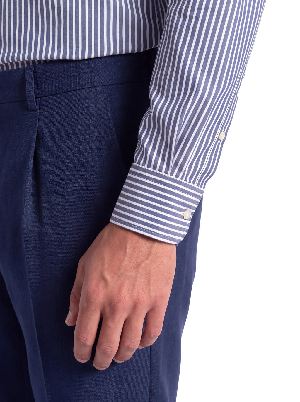 Camicia uomo a righe bianche su fondo blu grigio, dettaglio polso
