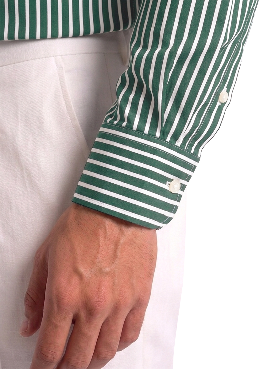 Dettaglio del polso della camicia uomo a righe verdi su fondo bianco